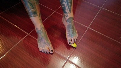 Tattooed Lady Crushes A Banana With Her Gams